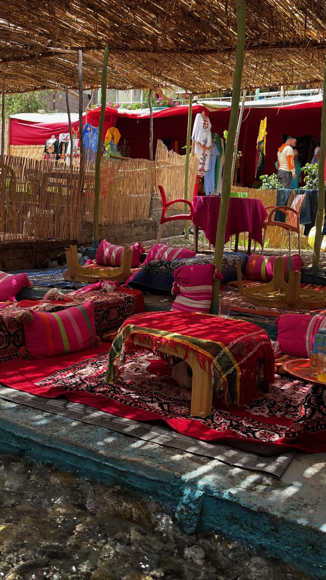 Salon marocain coloré sous une tonnelle de roseaux