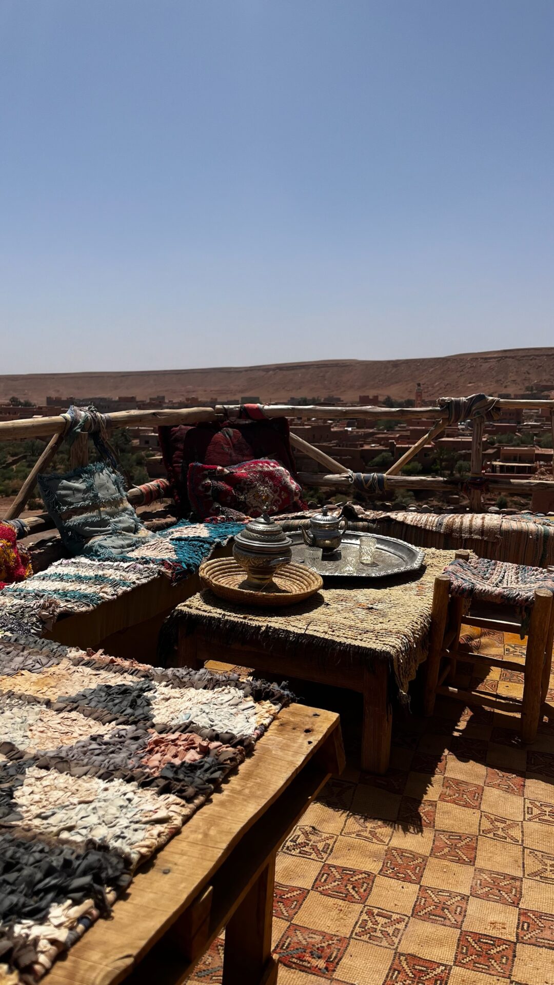 Terrasse garnie de tapis berbères face au paysage aride