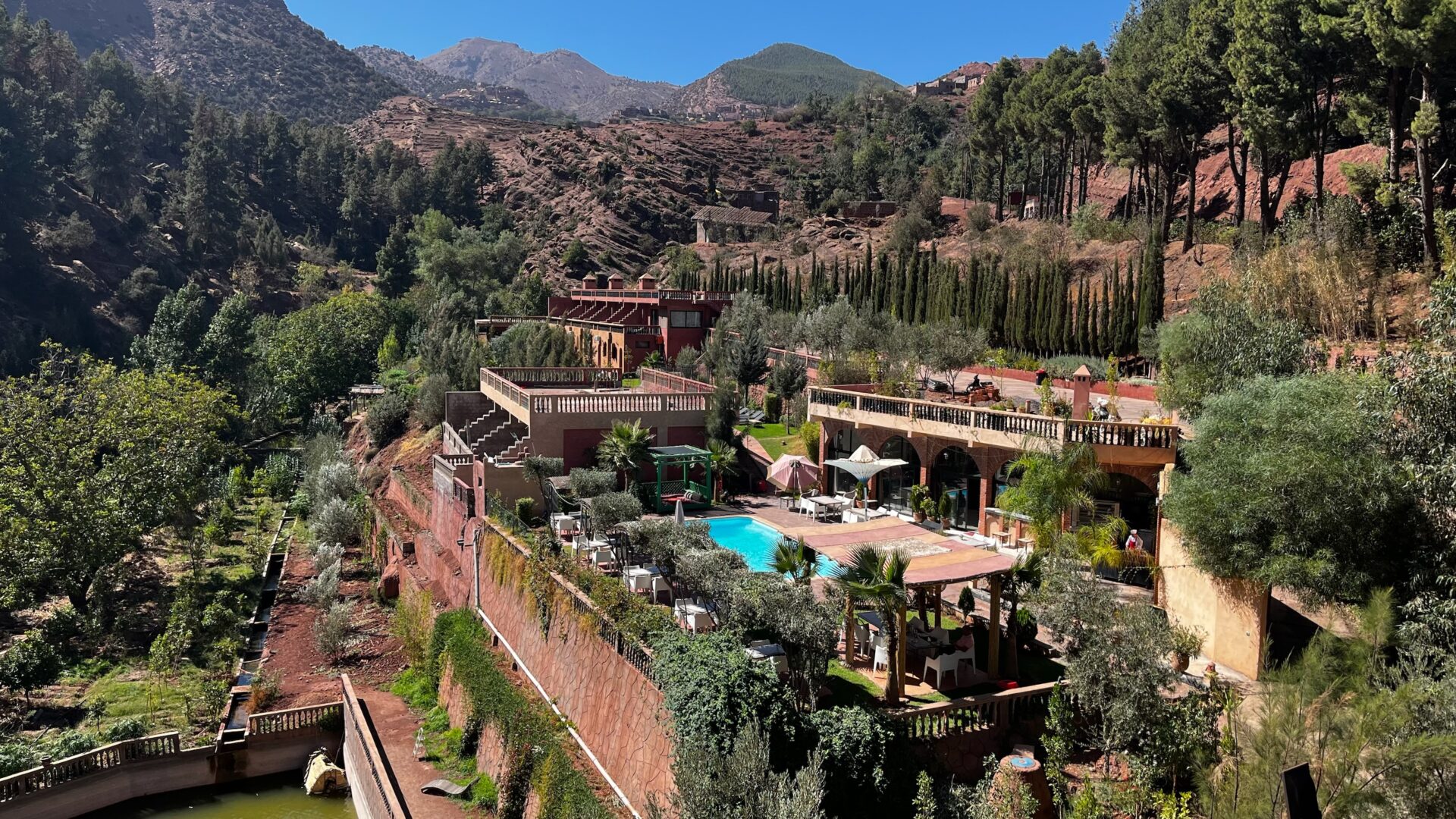 Vue plongeante sur un domaine et sa piscine au cœur des montagnes