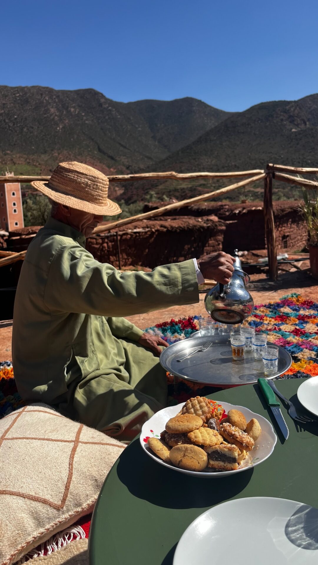 Service du thé marocain sur une terrasse face aux montagnes