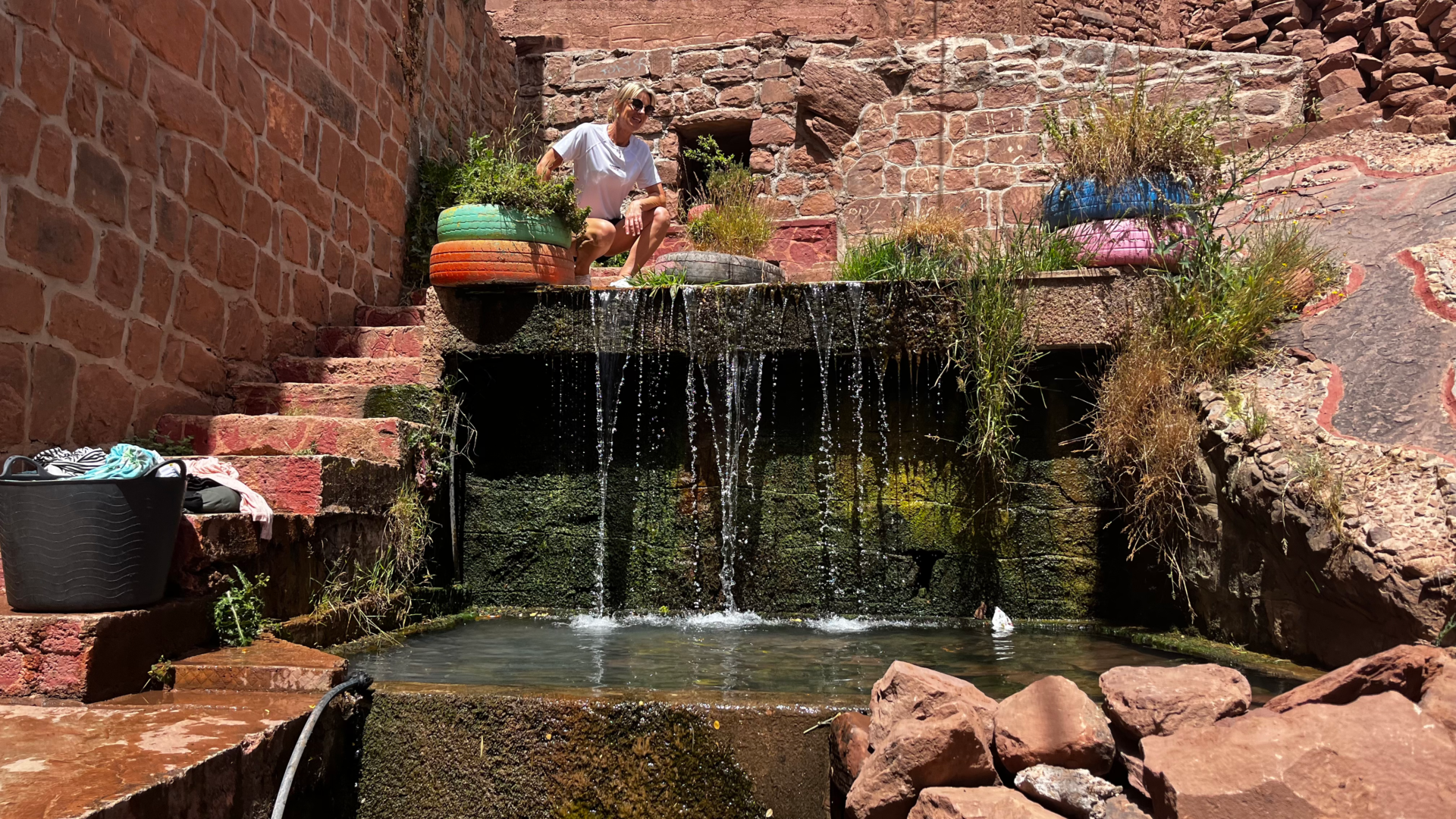 Fontaine en cascade dans un village en pierre rouge